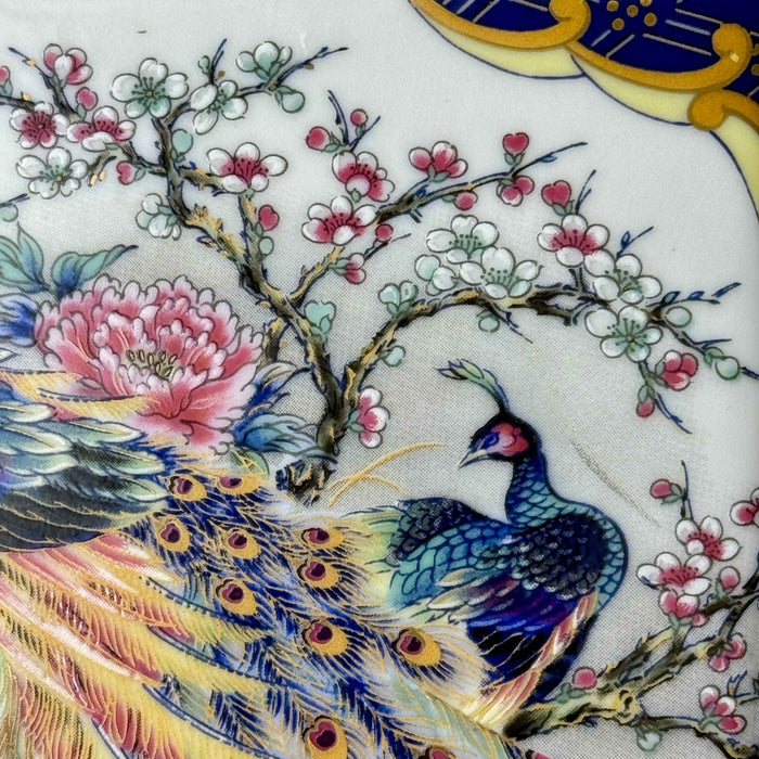 Detail view of the front panel showing colorful peacocks, peonies, and flowering branches on a vintage ceramic lamp