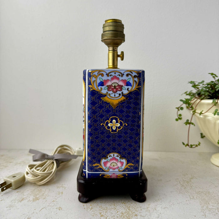 Alternate side view of the vintage peacock lamp showing floral side motifs and ceramic panel detailing