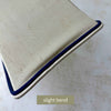Close-up of the original cream lamp shade showing a slight bend to one side panel and navy trim detail