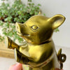 Close-up side view of second vintage brass pig bookend showing its sculpted face, raised front hooves, and aged brass finish.