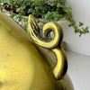 Close-up of the curled tail on the second vintage brass pig bookend, showing darkened recessed details.