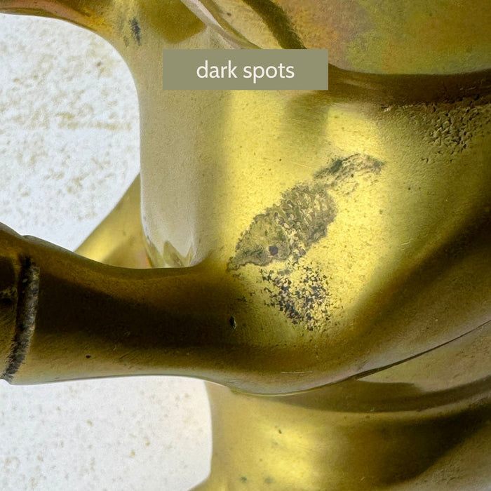 Close-up showing dark spots on the body near the front leg of second brass pig bookend.