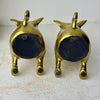 Underside view of both vintage brass pig bookends showing black felt-covered bases and small felt pads.