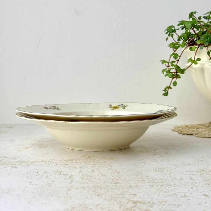 Side view of two stacked Syracuse China Portland rimmed soup bowls showing their broad shallow shape and scalloped gold-trimmed rims.