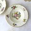 Overhead view of a Syracuse China Portland soup bowl showing the central mixed-flower bouquet and smaller floral sprays around the scalloped rim.