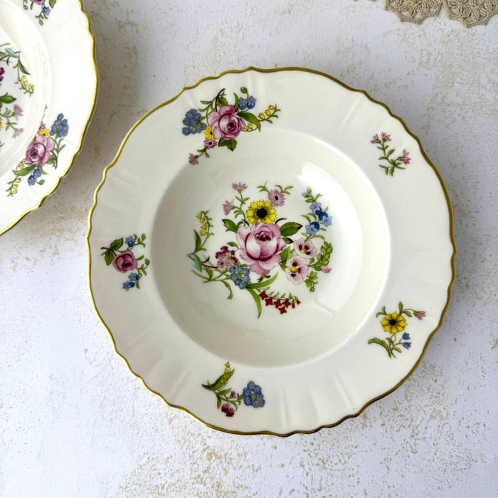 Overhead view of a Syracuse China Portland soup bowl showing the central mixed-flower bouquet and smaller floral sprays around the scalloped rim.