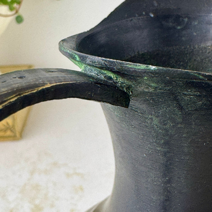 Close-up of upper handle attachment and rim showing green oxidation and wear to the black finish.