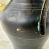 Close-up beside the lower handle attachment showing scratches, finish wear, exposed brass, and green oxidation.