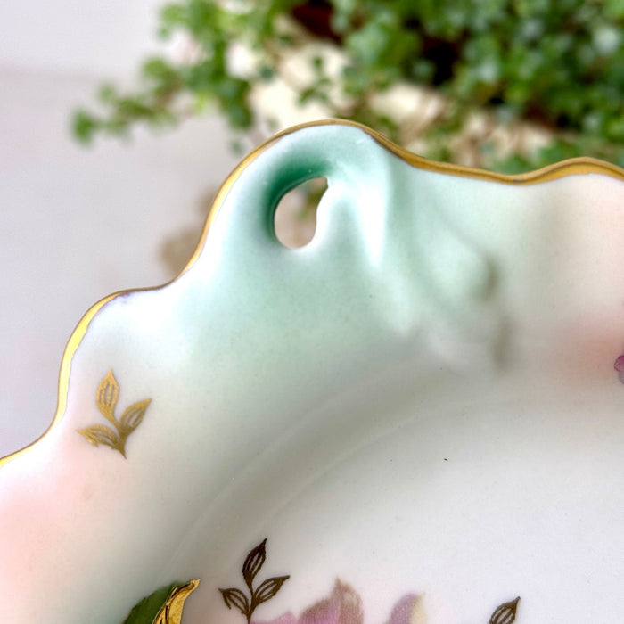 Close-up of the curved leaf tip and open loop on the Schumann Arzberg dish, with aqua and mauve shading and gold details.