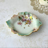 Vintage Schumann Arzberg porcelain trinket dish with mauve florals, aqua shading, scalloped leaf form, and gold details.