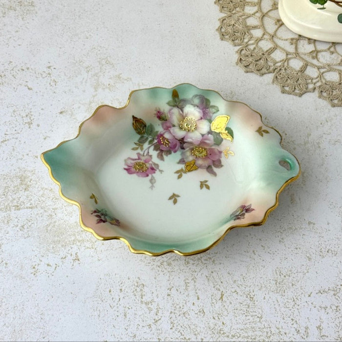 Vintage Schumann Arzberg porcelain trinket dish with mauve florals, aqua shading, scalloped leaf form, and gold details.