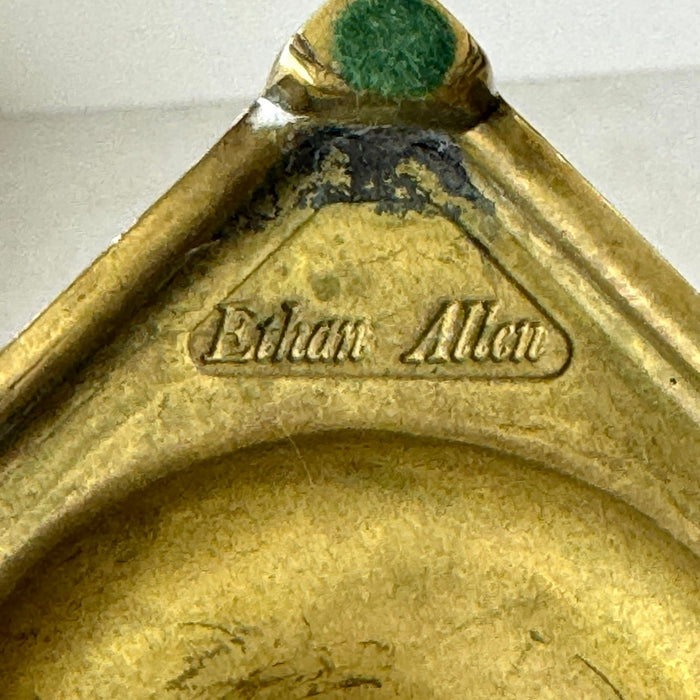 Close-up of Ethan Allen maker mark on the underside of the shorter solid brass candlestick.