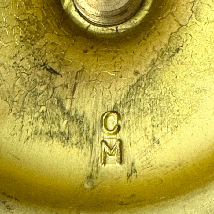 Close-up of CM mark on the underside of the taller vintage brass candlestick.