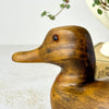 Opposite-side close-up of the wooden duck’s head showing the carved bill, rounded head, wood grain, and glass eye.