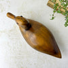Overhead view of the vintage carved wooden duck showing its long oval body, tapered tail, and natural wood grain.
