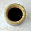 Overhead view of small stoneware crock showing the thick buff rim and very dark glazed interior.