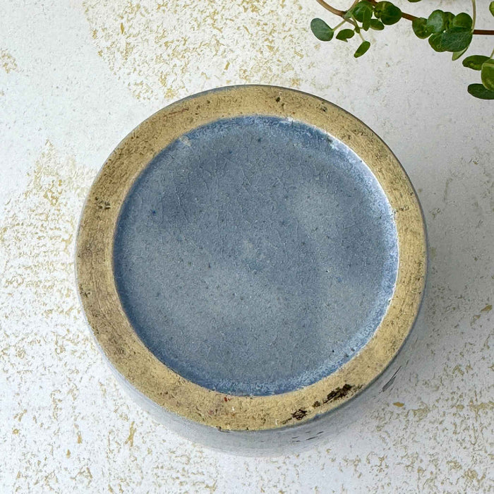 Underside of vintage gray-blue stoneware crock showing the glazed base and broad unglazed buff foot ring.