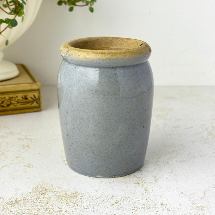 Small vintage gray-blue stoneware crock with a thick buff-colored rim and simple utilitarian form.