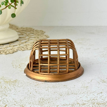 Vintage copper-colored Vogue No. 71 cage flower frog with a gridded top and sides on a round base.