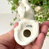 Underside of ceramic dog figurine showing the open base and black HAND PAINTED mark.