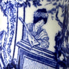 Close-up of Blue Mikado decoration showing a seated woman playing a stringed instrument beneath a tree.