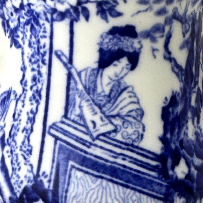 Close-up of Blue Mikado decoration showing a seated woman playing a stringed instrument beneath a tree.