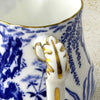 Close-up of Royal Crown Derby creamer showing the curved handle with blue decoration and gold detailing.