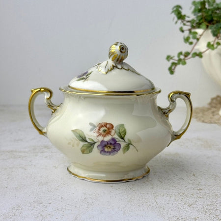 Vintage Hutschenreuther covered sugar bowl in cream porcelain with muted floral decoration, gilded handles, and acorn-and-oak-leaf finial.