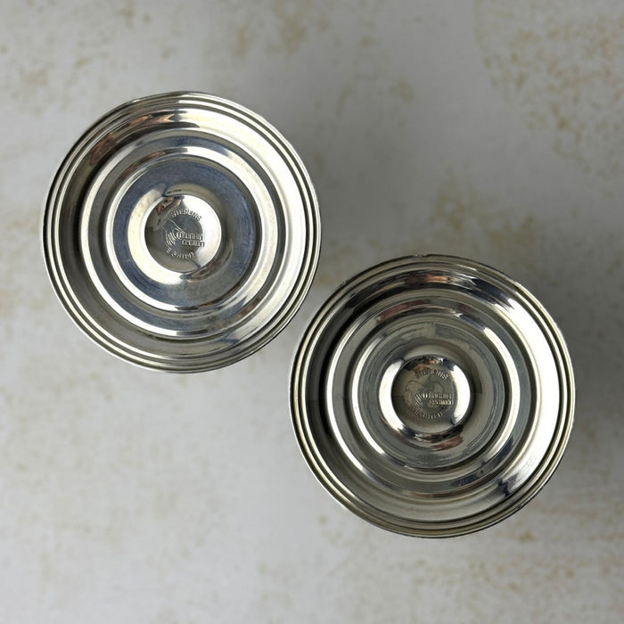 Undersides of two Duchin weighted sterling silver candlesticks, showing circular bases with stamped maker's marks.