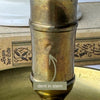 Close-up of the brass chamberstick stem with an arrow identifying a small dent in the metal.