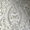 Close-up of the tray's embossed decoration showing an oval floral motif surrounded by elaborate scrollwork and textured details.