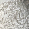 Close-up of the tray's embossed decoration showing scrolling foliage, curved ornamental bands, and finely textured areas.