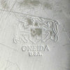 Close-up of the Oneida U.S.A. maker's mark with an OL shield and animal figures stamped into the scratched underside of the tray.