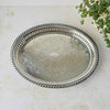 Overhead view of the oval silverplate tray showing its symmetrical floral scrollwork design, pierced gallery railing, and decorative outer rim.