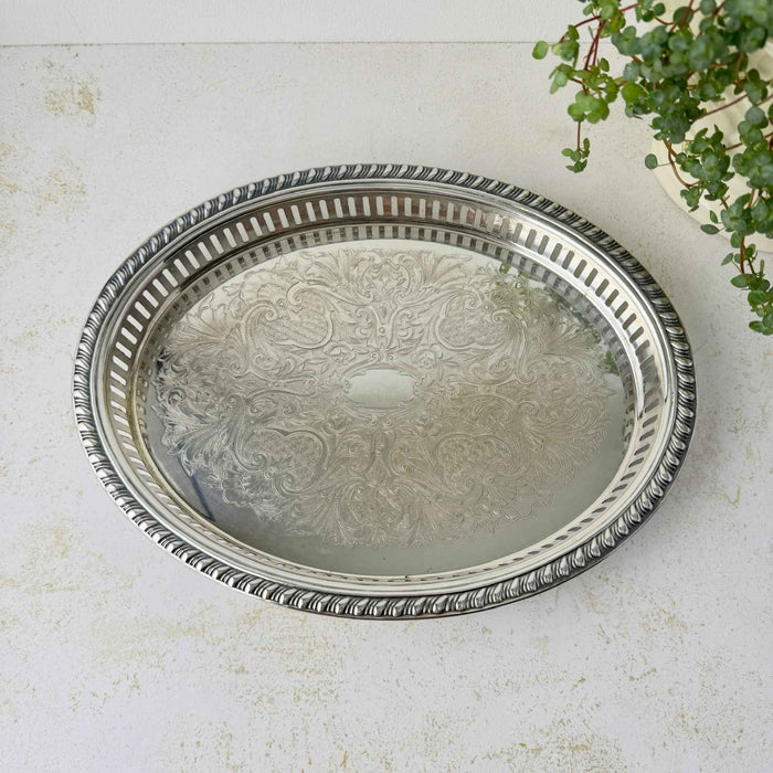 Overhead view of the oval silverplate tray showing its symmetrical floral scrollwork design, pierced gallery railing, and decorative outer rim.