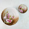 Antique Carl Tielsch porcelain bowls, set of two — large bowl and small bowl, both with pink roses on shaded brown ground and embossed rims, overhead view
