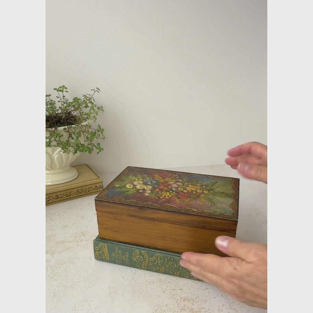 Vintage wooden box with floral decoupage lid is opened and tilted to show the box interior