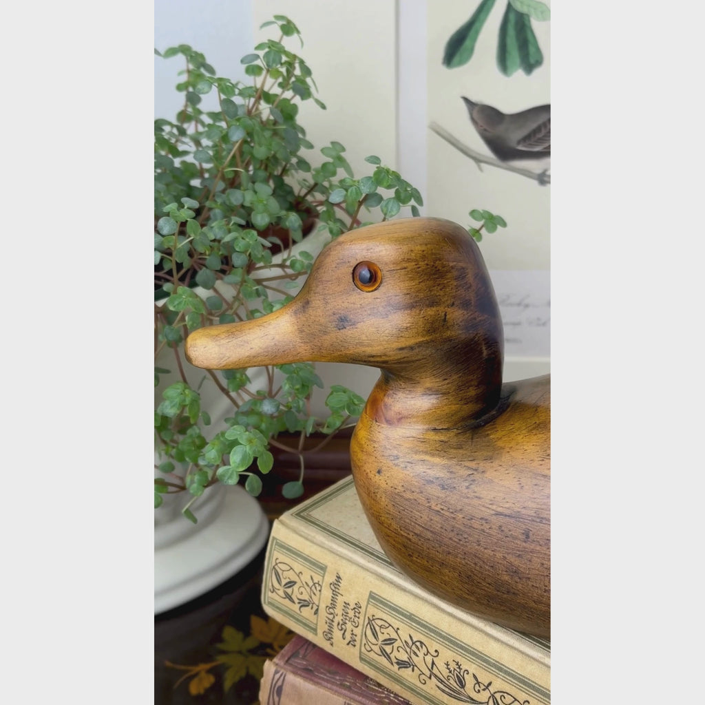 Vintage hand-carved wooden duck shown close-up from the head to the tail and then from above back to the head.