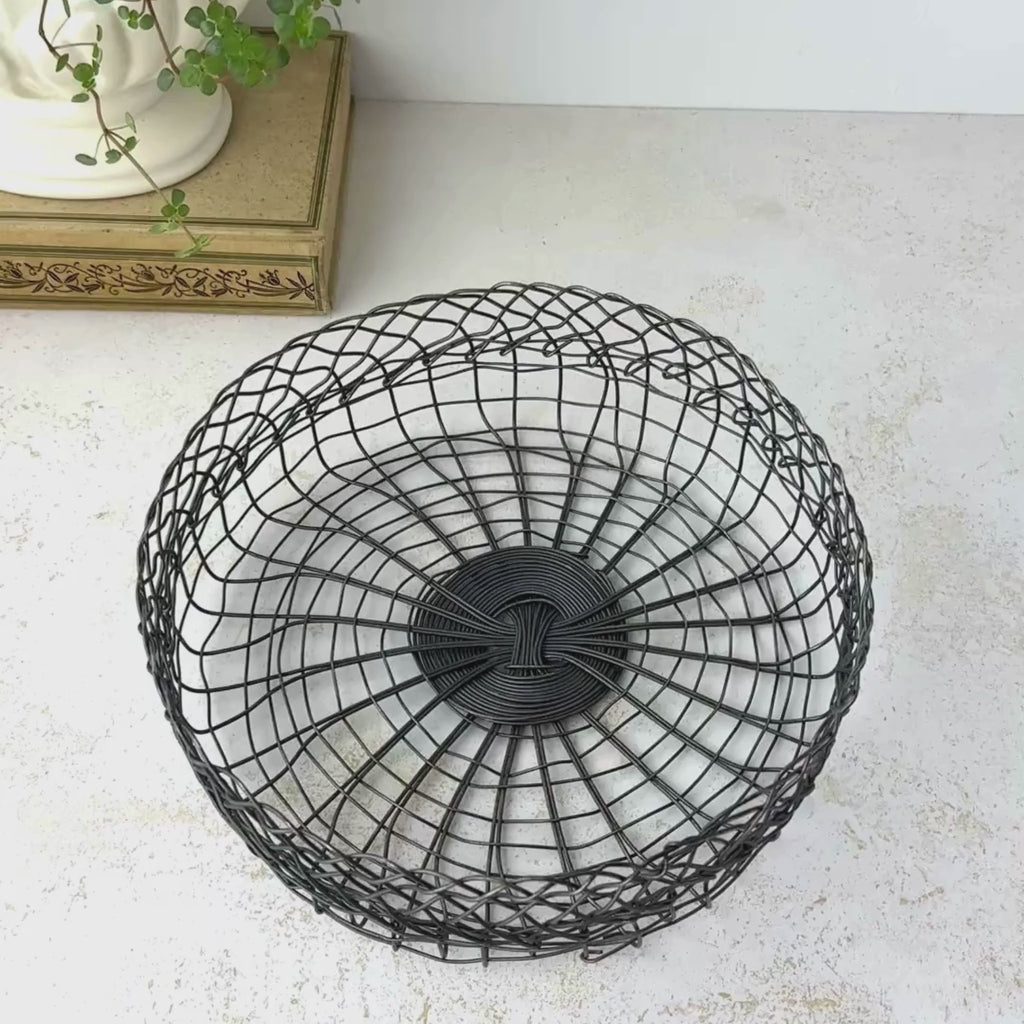 Vintage shallow round wire basket shown on a neutral backdrop as the camera pans from above to a front profile view