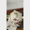 Vintage Sadler England teapot shown from  above and then in profile from spout to handle displaying the pink, blue, and golden-brown floral bouquets, ribbed cream ceramic body, and gold trim.