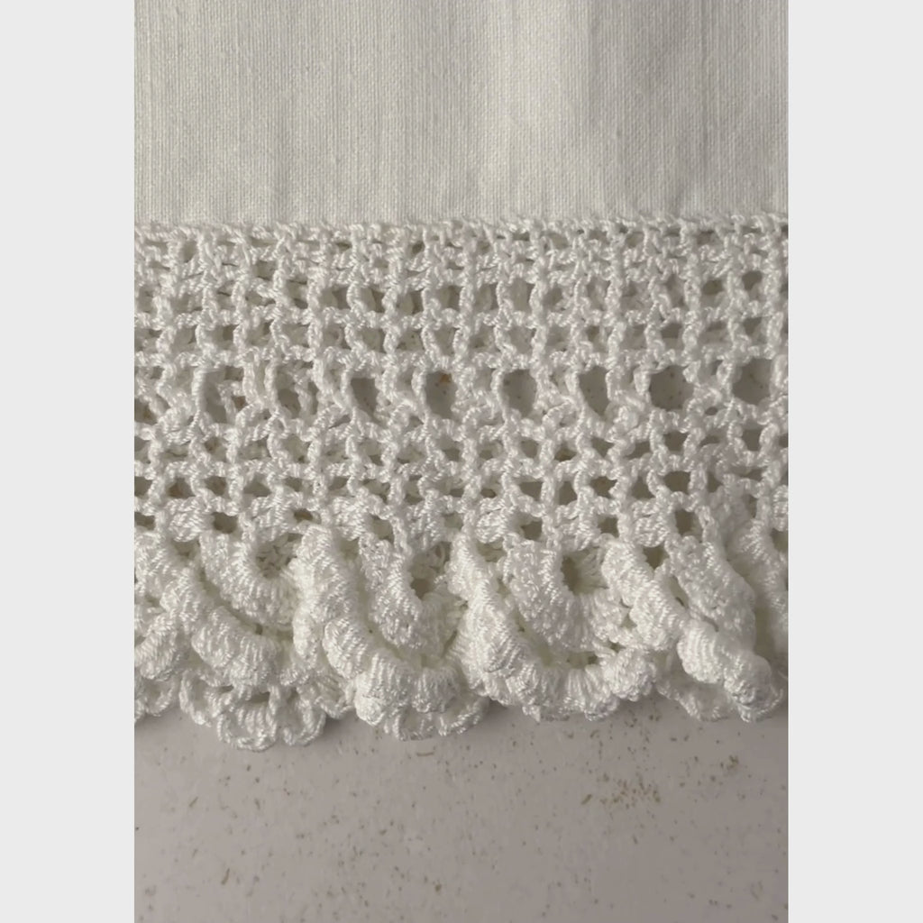 Close-up pan of crochet scallop lace border on vintage pillowcase