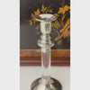 Close-up video of a pair of vintage candlesticks showing the silverplate candle cups and then down the turned silverplate and lucite stem to the flared silverplate base.