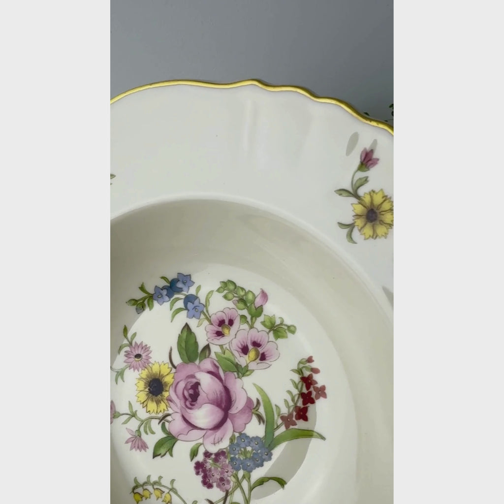 Video of vintage Syracuse China Portland rimmed soup bowl with multicolored floral bouquets, scalloped ivory rims, and gold trim.