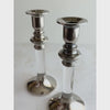 Short video of silver lucite candle holders being picked up and turned to show its shape, finish, and details in natural light