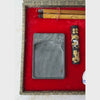 Open vintage Chinese calligraphy set in a fitted textile-covered box with red lining shown close-up starting with the brushes, inkstone and ink on the left to the carved seal, brass spoon, and porcelain tools on the right