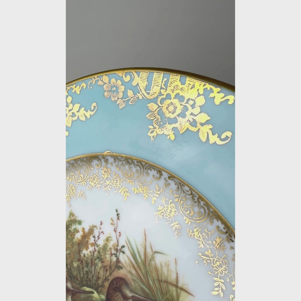 Close-up video of ornate gold flowers, foliage and basket motifs on the turquoise blue porcelain rim.