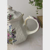 Vintage Sadler Windsor teapot with multicolor floral decoration, embossed basket-weave sides, and gold trim styled with trailing plant shown from a handle close-up to pulling back to reveal the entire teapot