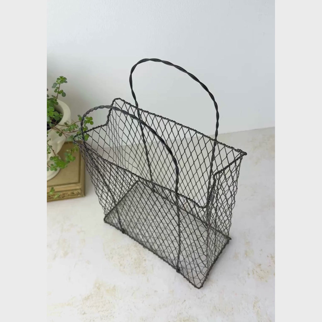 Vintage wire basket with paper bag form shown on a neutral backdrop, panning from overhead to the basket front