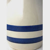 Vintage beige stoneware pitcher shown close-up from the two cobalt blue bands up to the pouring spout and loop handle and back to the blue bands